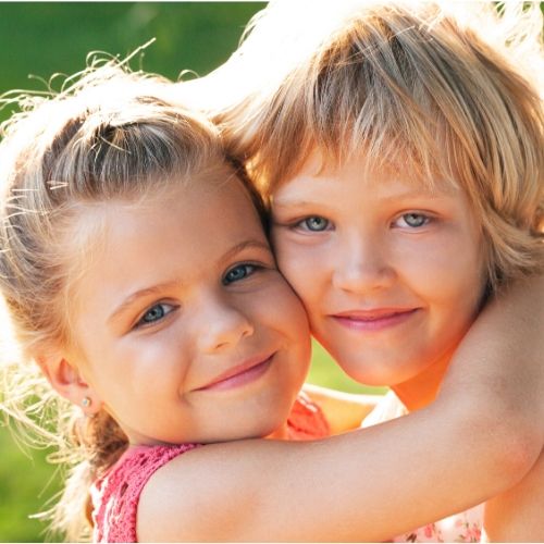 two girls hugging, showing how head lice passes from head to head contact