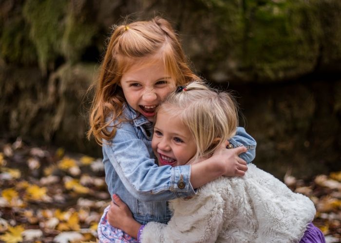 two young girls hugging, a way to pass head lice