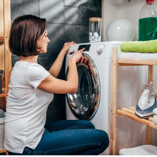 woman putting lice infested clothing in dryer