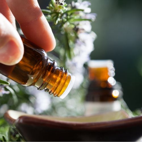 essential oil bottle being poured, presumably to act as a repellent for head lice.