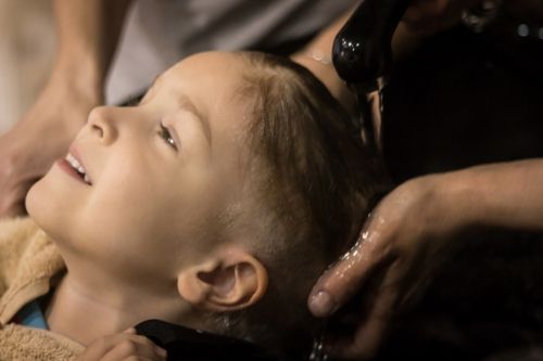 washing child's hair, presumably after a lice treatment