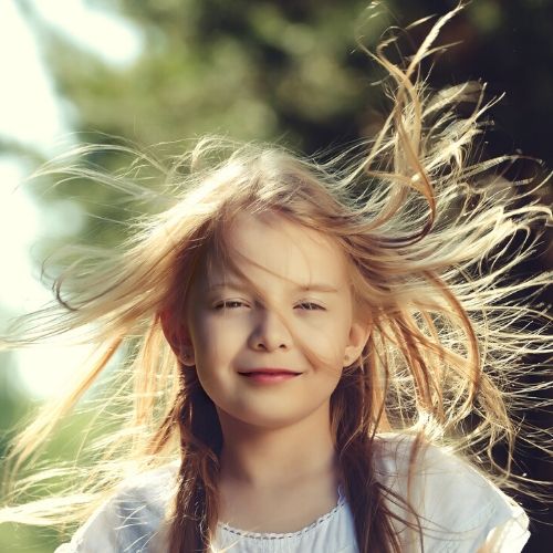 child with hair blowing, presumably child has lice