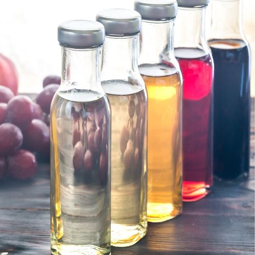 5 different types of vinegar in bottles, presumably to be used on head lice