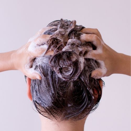 woman washing her hair with lots of suds