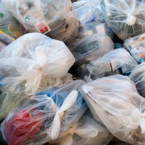 multiple garbage bags with toys, clothing and stuffed animals after a lice infestation