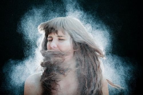 woman shaking baking soda out of her hair, presumably using baking soda as a lice treatment