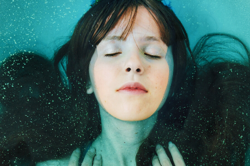 woman presumably with head lice soaking her hair in chlorinated pool water to kill lice