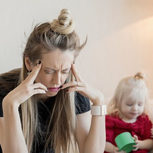 mother with a headache, presumably frustrated with lice