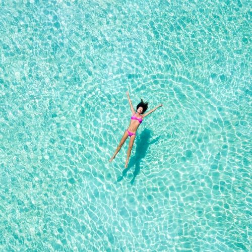 woman in bikini in large chlorinated pool, presumably trying to kill lice with chlorine