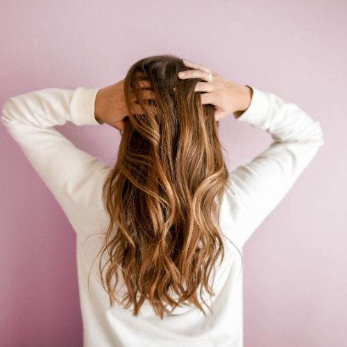 woman putting hand through her hair for neem lice prevention