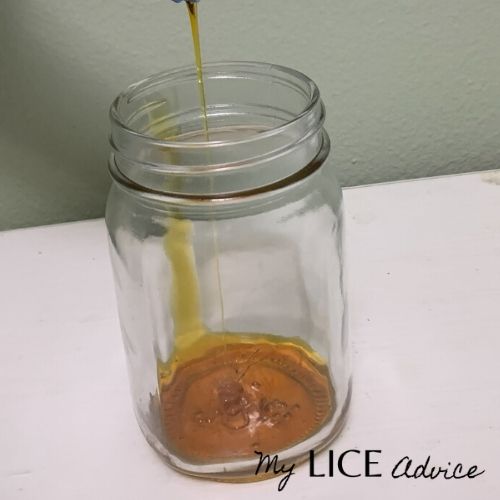 jar full of lice and neem oil being poured on the lice as a neem lice treatment