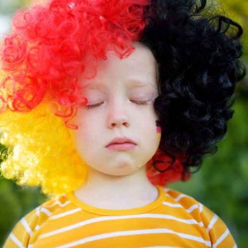 child wearing a wig and very sad, presumably because her hair was cut related to head lice