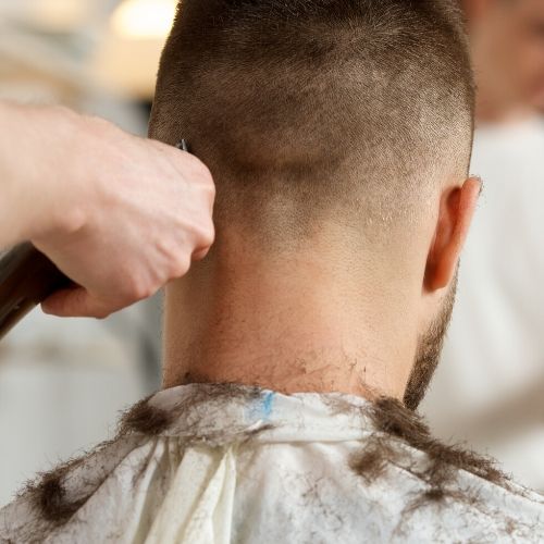 adult man getting his head shaved, presumably for head lice