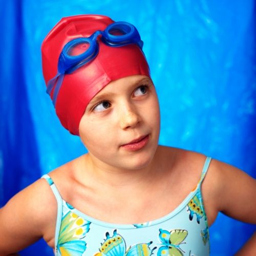 child wearing a swim cap, presumably to prevent getting head lice