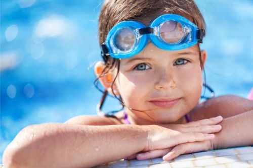 small child with googles in a chlorinated swimming pool, presumably with head lice.