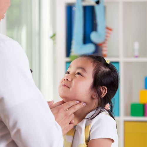 A doctor is checking a child's lymph nodes