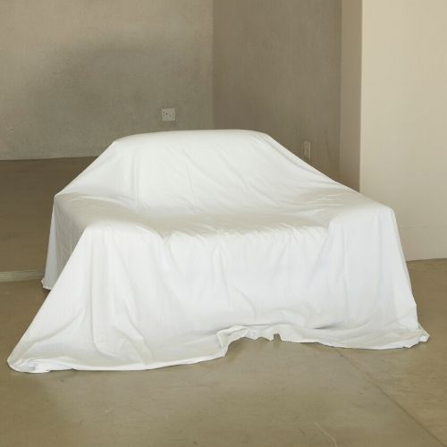 A couch covered in a clean white sheet