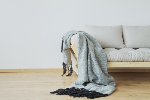 A couch with a throw blanket on it.