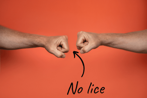 two people fist bumping, showing an alternative that does not spread lice