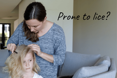 mother checking blonde daughter for head lice