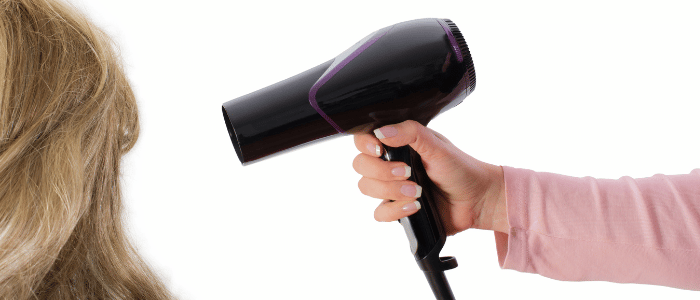 woman blow-drying hair presumably blow-drying for lice