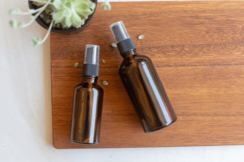 two brown spray bottles, presumably filled with lice prevention spray