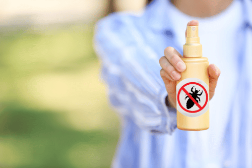 woman holding bottle of lice prevention spray