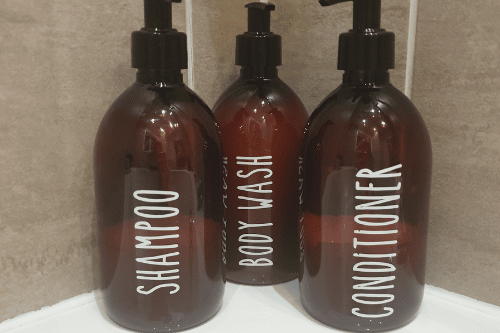 bottles of shampoo, conditioner, and body wash on a shower shelf