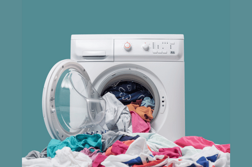 overloaded washing machine with clothes falling out
