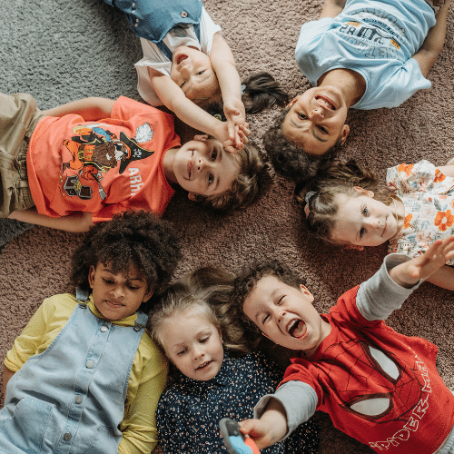 multiple children presumably with head lice with their heads on the carpet